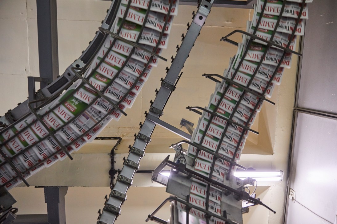 Times of India newspapers on printing press rollers with mechanical clamps during production.