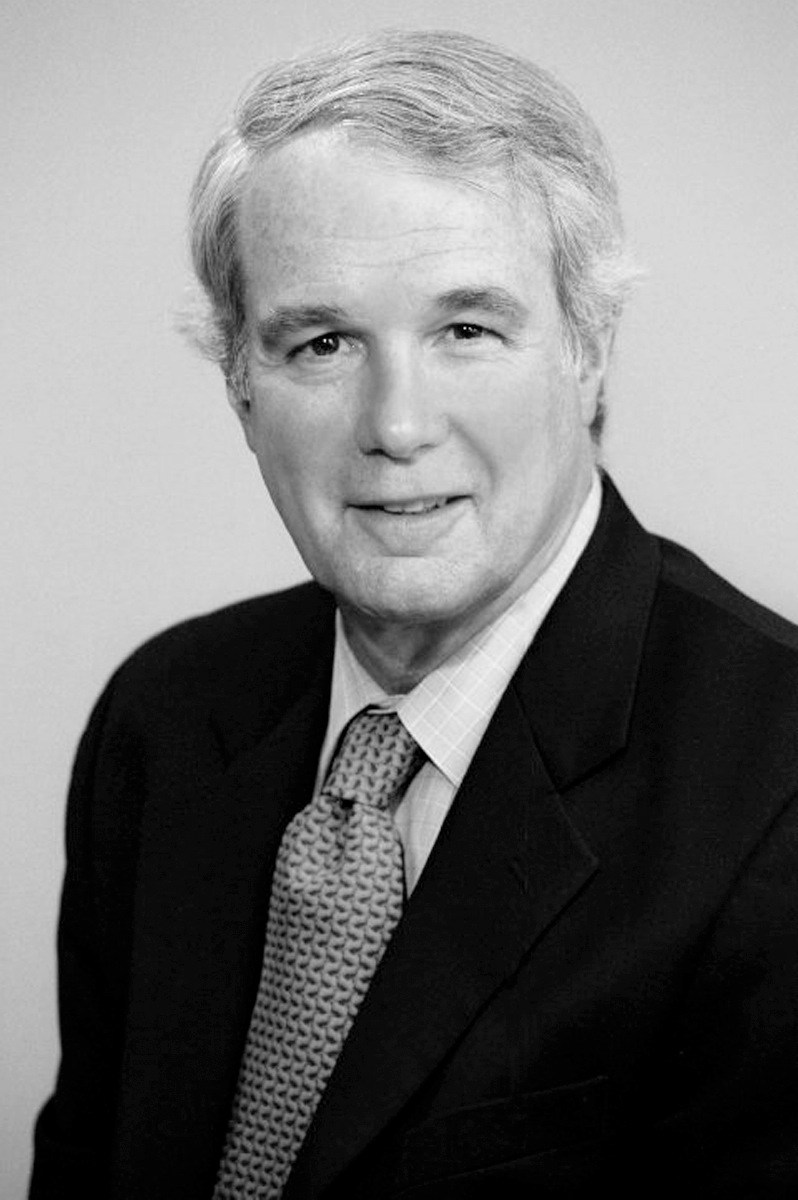 Black and white portrait of Colin I Bradford Jr, a man wearing a dark suit and patterned tie.