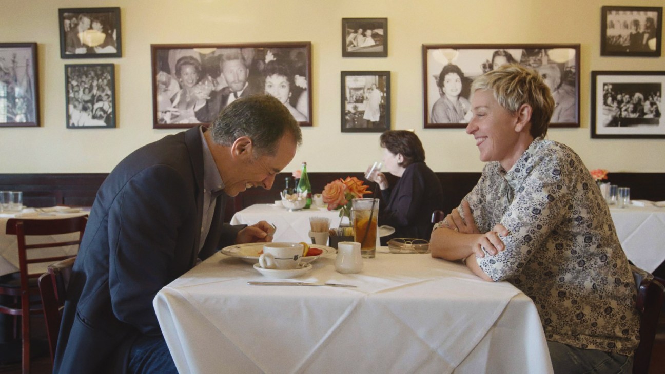 Two diners in a restaurant with vintage black and white photographs on the walls behind them.