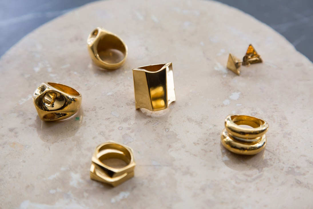 Felina gold jewellery rings and earrings displayed on a marble surface.
