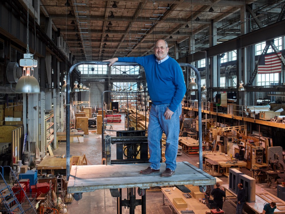 Michael Stiegelbauer stands on a platform in his scenic shop hangar at the Brooklyn Navy Yard.
