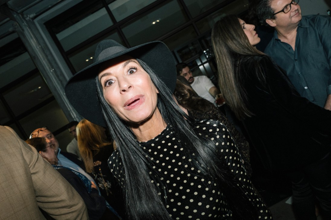 Woman in black hat and polka dot dress looking up at art in museum gallery
