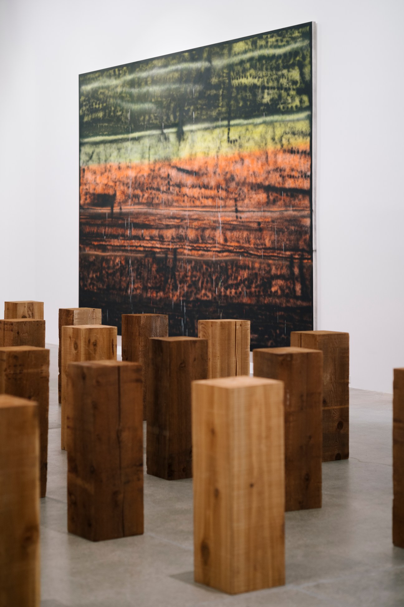 Sterling Ruby's 'SP173' painting on wall behind Carl Andre's wooden block sculptures arranged on gallery floor