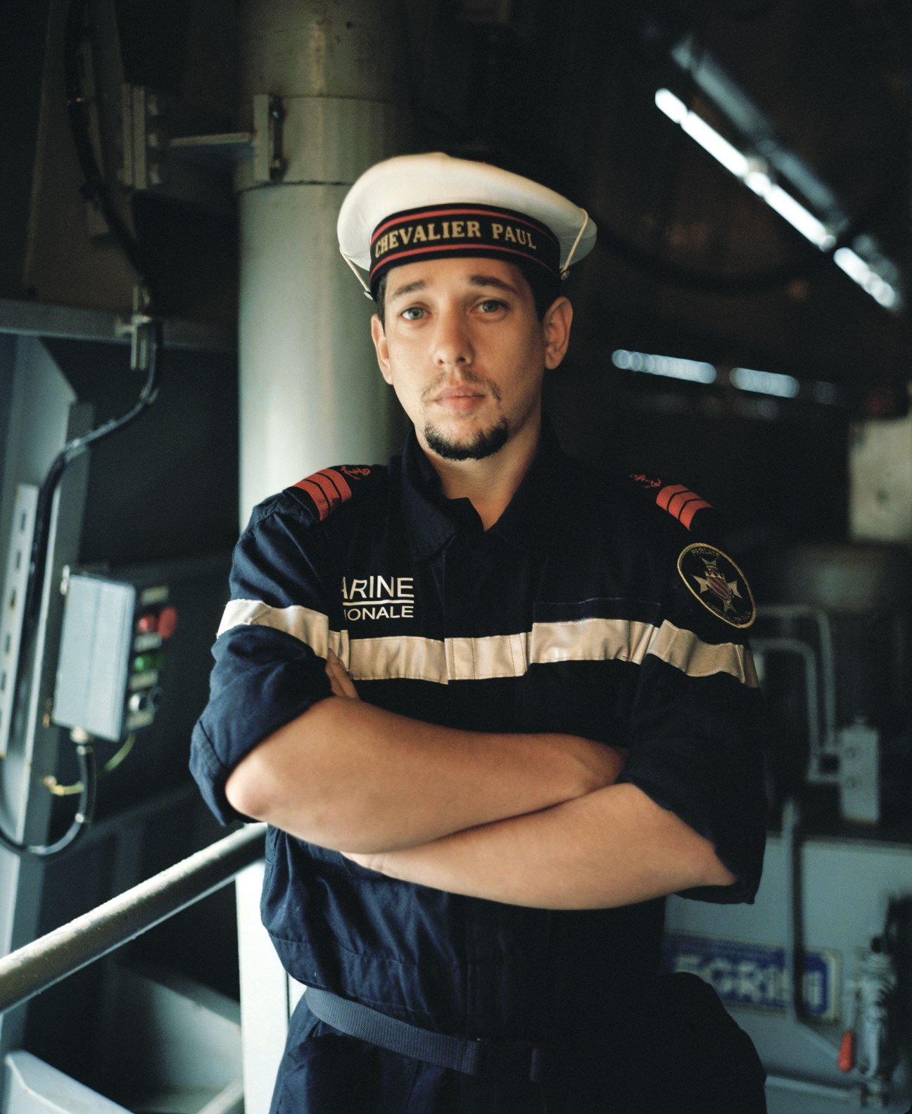 French sailor in navy uniform with red shoulder boards aboard the Chevalier Paul destroyer.
