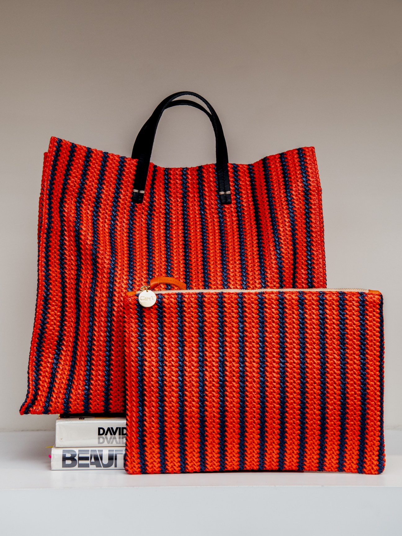 Red and navy striped leather tote bag with black handles by Clare V.