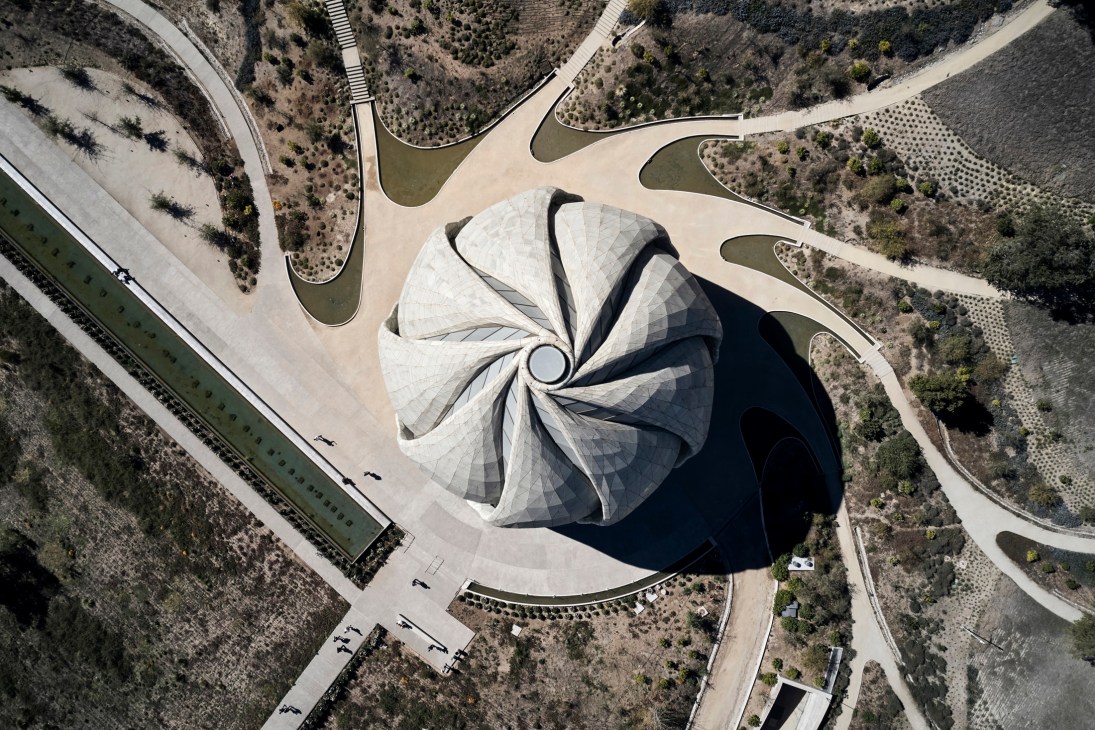 Aerial view of the Baha'i House of Worship in Santiago, Chile with its distinctive circular dome surrounded by nine paved paths and landscaped grounds.