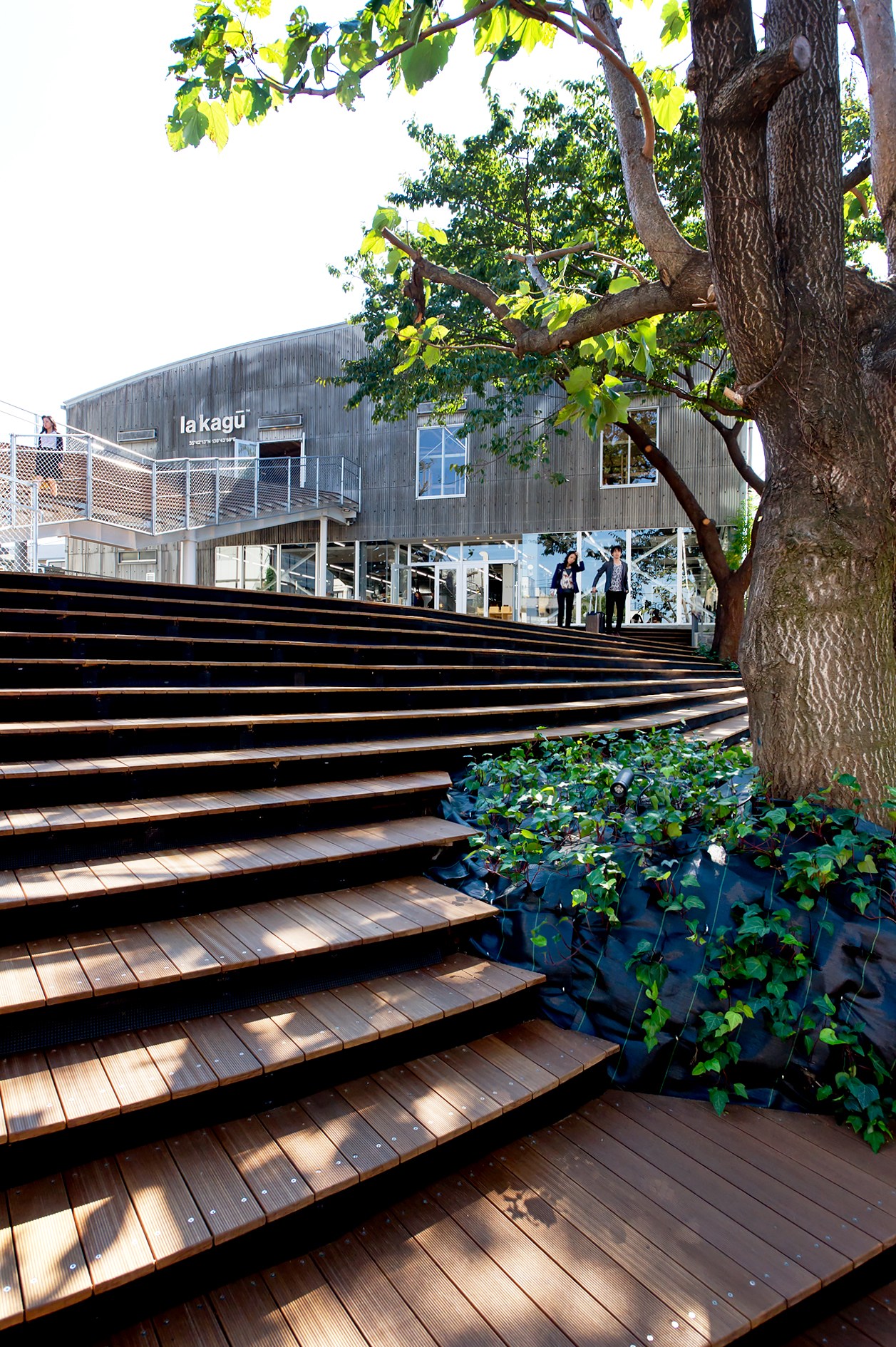 La Kagu's wooden deck with metal stairs leading to the corrugated-steel warehouse building in Tokyo.