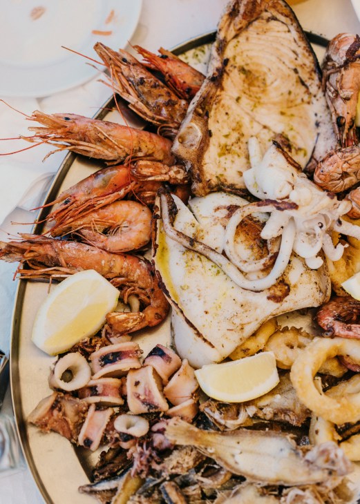 Grilled seafood platter with prawns, squid, fish and lemon wedges at La Pepica