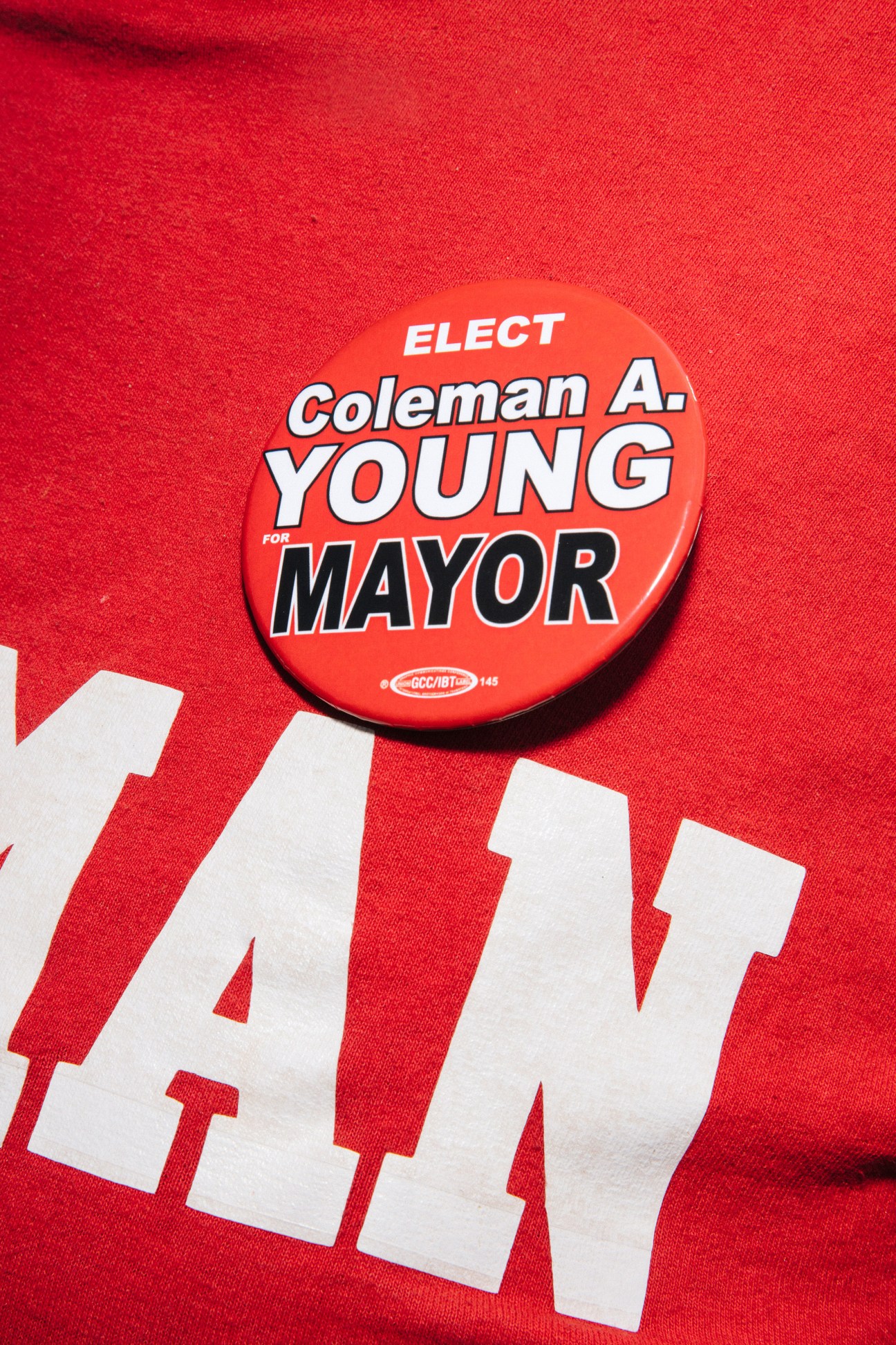 Campaign button for Coleman A. Young II on red fabric with partial text visible below.