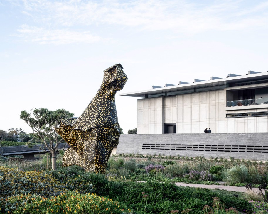 Large patterned sculpture of a bird outside the Norval Foundation building with landscaped gardens.