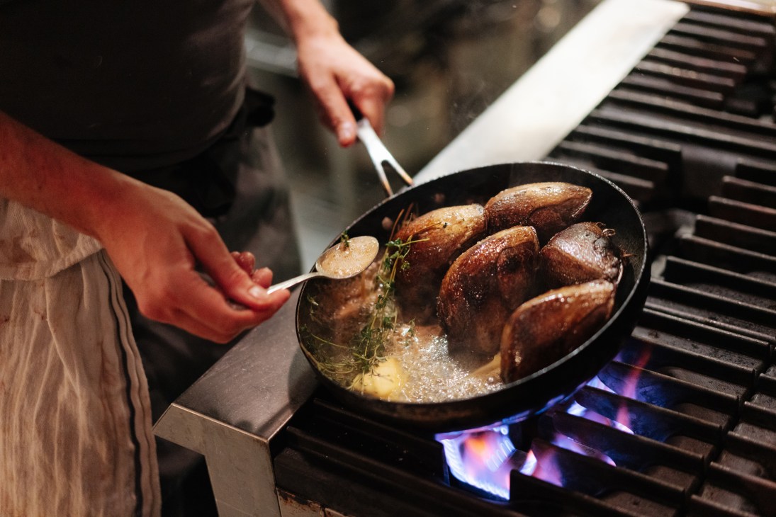 Pigeon breast being cooked in restaurant kitchen