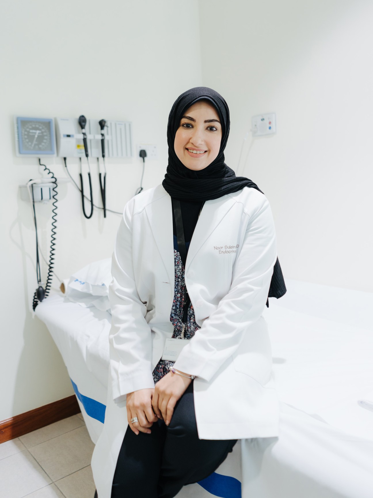 Medical professional in white coat and black hijab in consultation room at obesity treatment facility