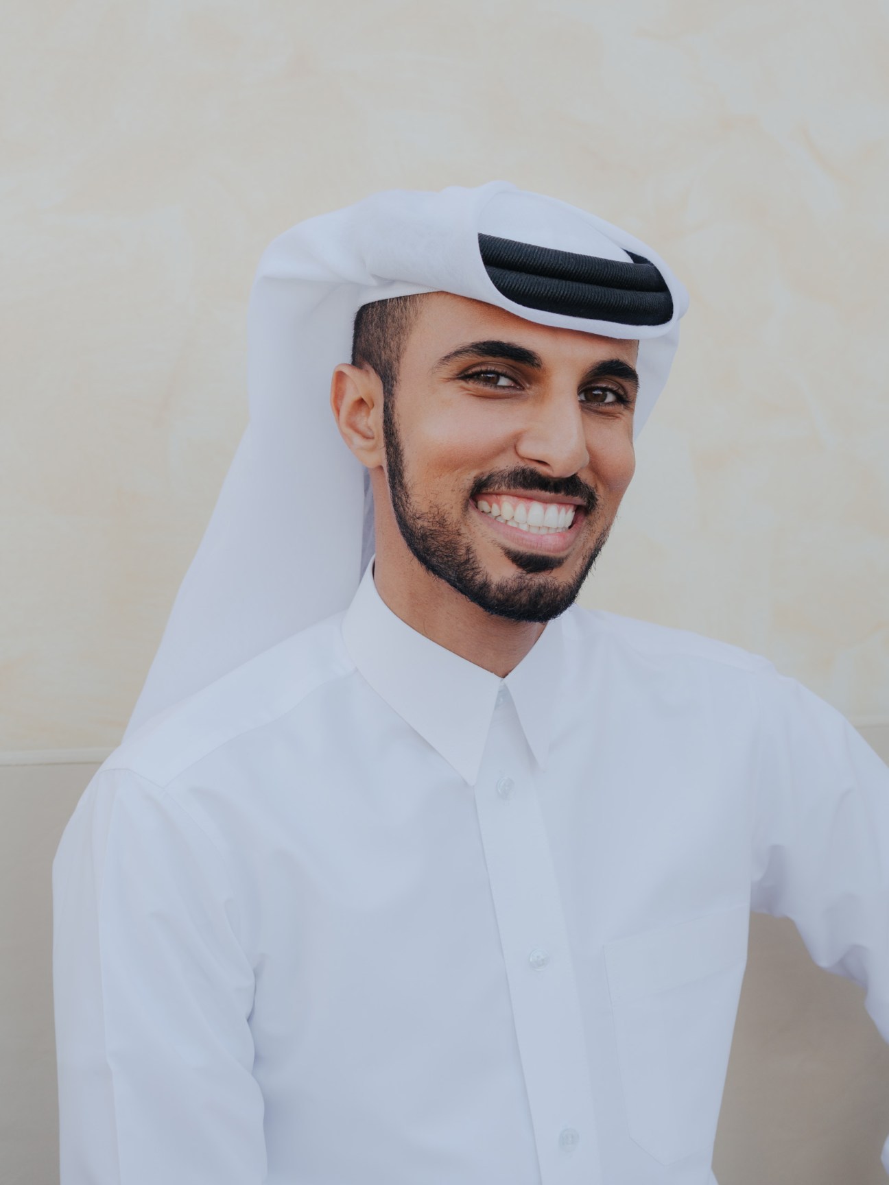 Ghanim al-Sulaiti sits outdoors holding a green juice at Evergreen Organics café in Doha.