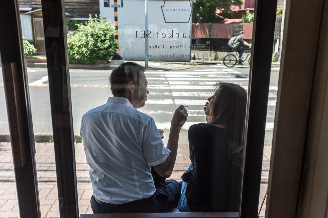 Two people tasting gelato at The Market SE1 gelateria in Japan, with one person holding a spoon to their mouth.