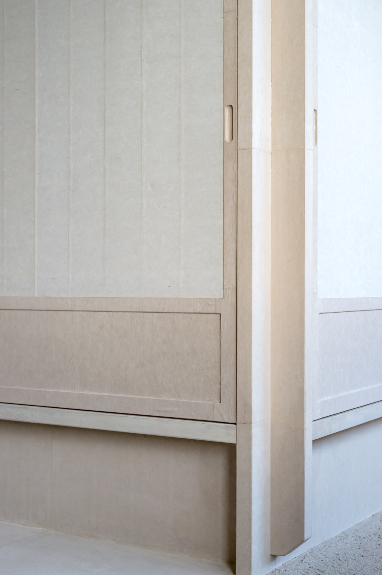 Detail of wooden door and frame showing fine carpentry with minimal handles and clean lines.