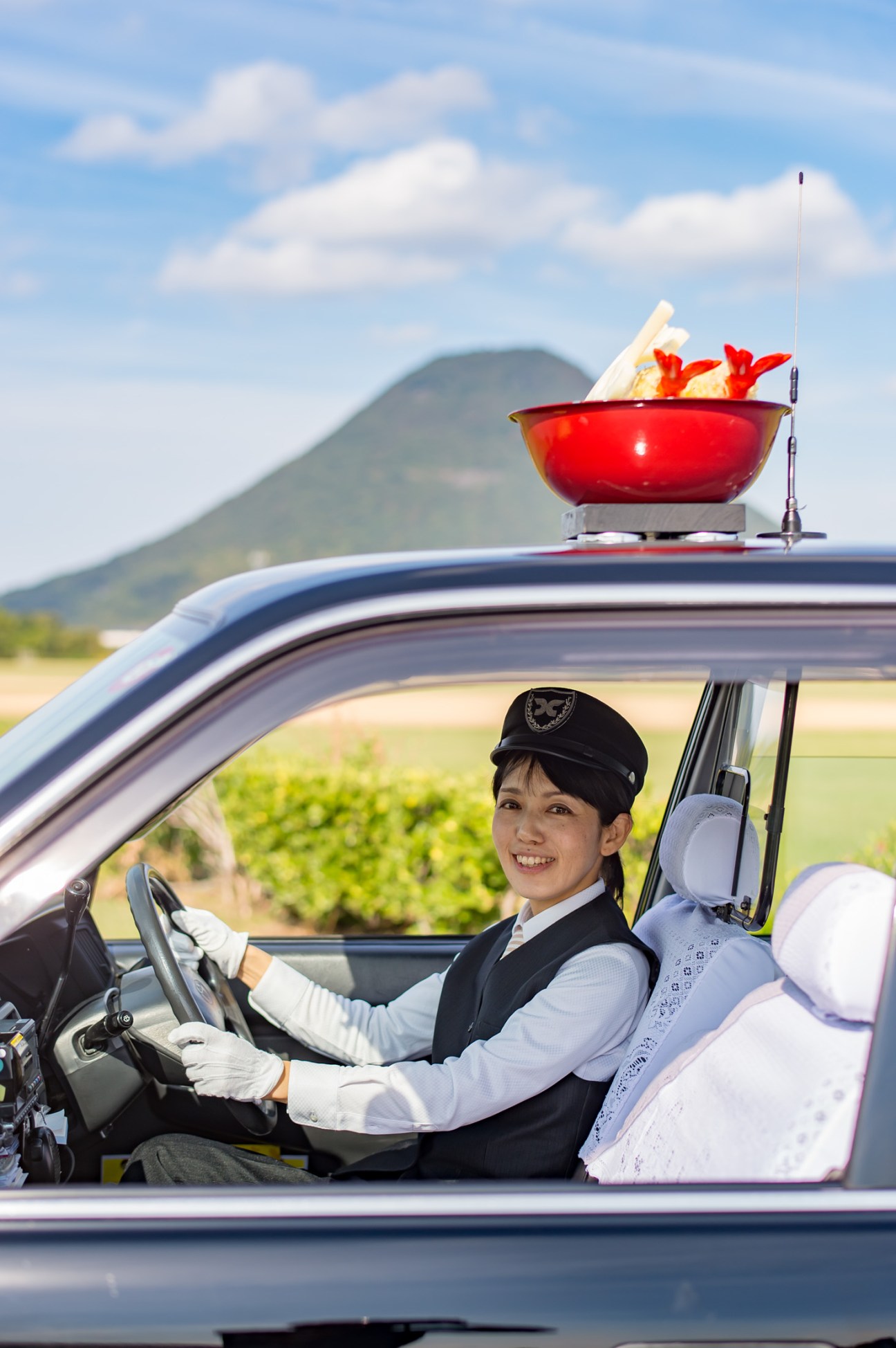 Jun Tada driving the Kotohira udon bus-taxi with ceremonial bowl on roof in Kagawa prefecture