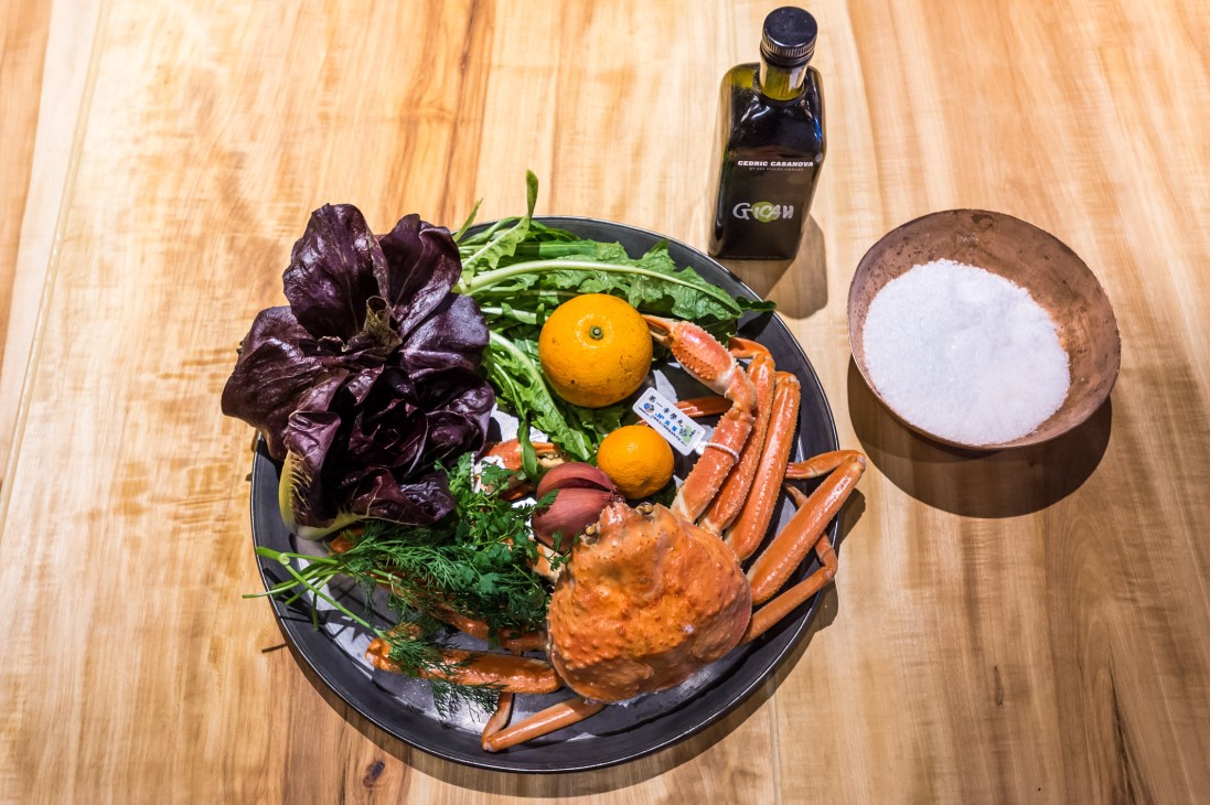 Winter crab salad with naval orange, purple radicchio, greens, citrus mayonnaise and oil on wooden surface