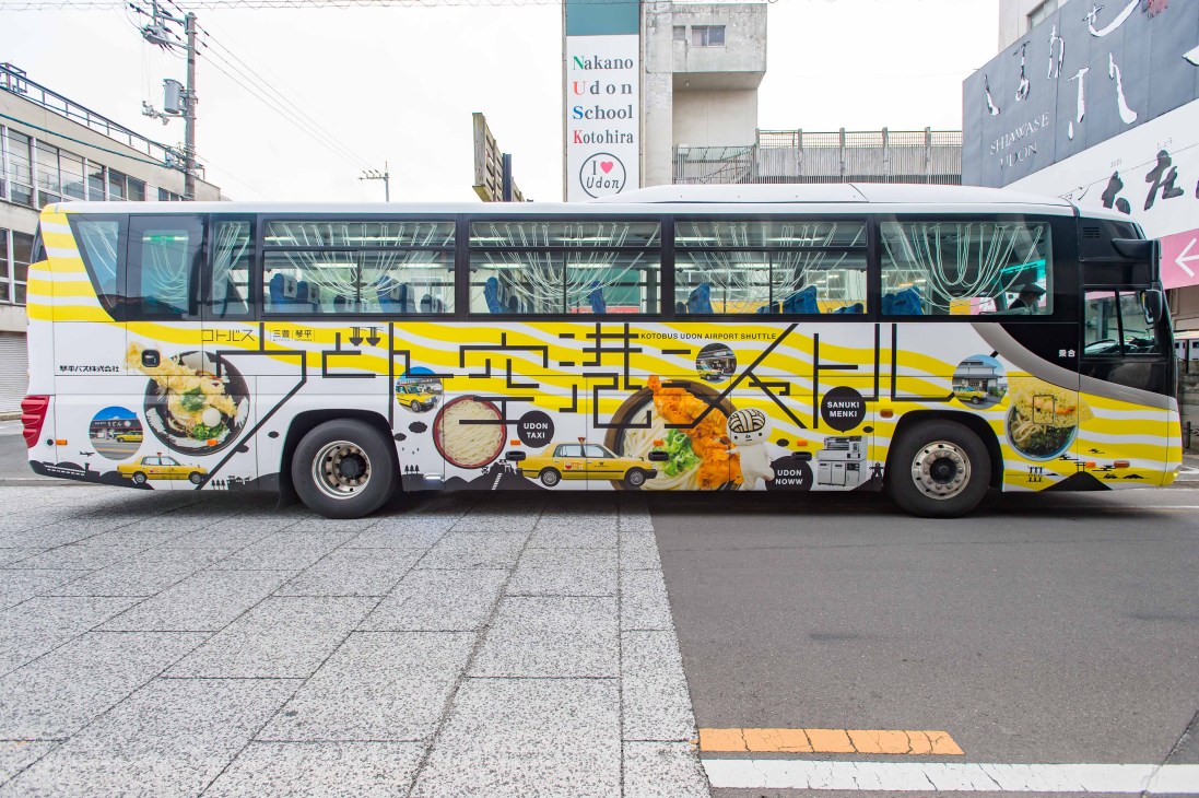 A dedicated udon tour bus with promotional graphics and signage