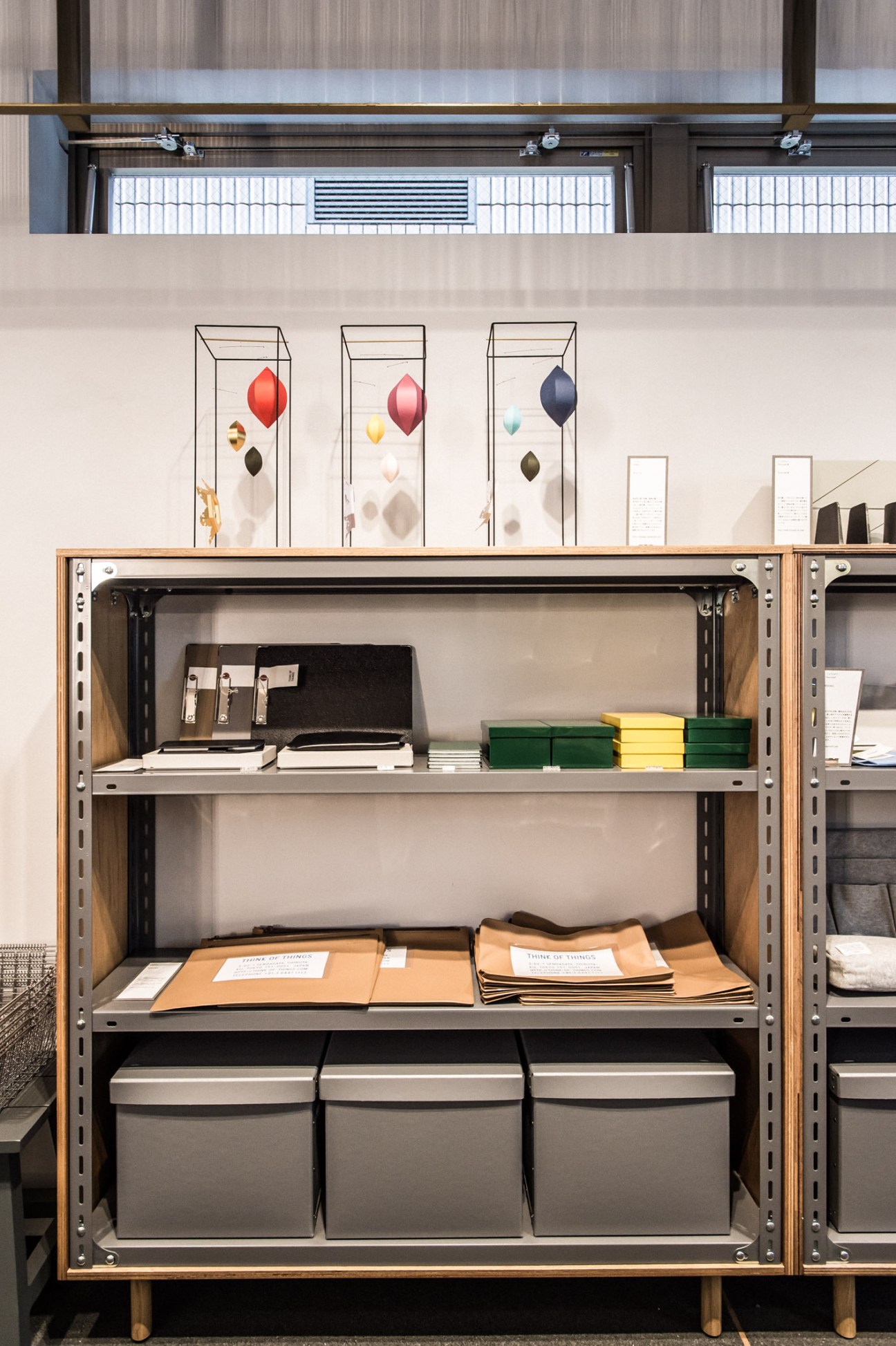Industrial shelving unit displaying stationery products including notebooks, folders, and office supplies