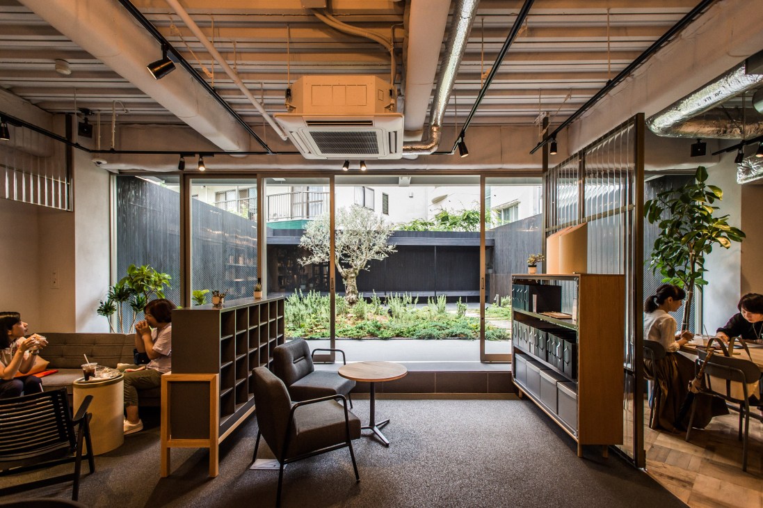 Interior view of Think of Things concept store showing seating area with garden view through large windows