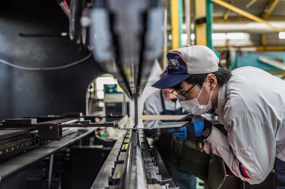 A factory worker bends sheets of metal at Kikukawa's manufacturing facility in Japan.