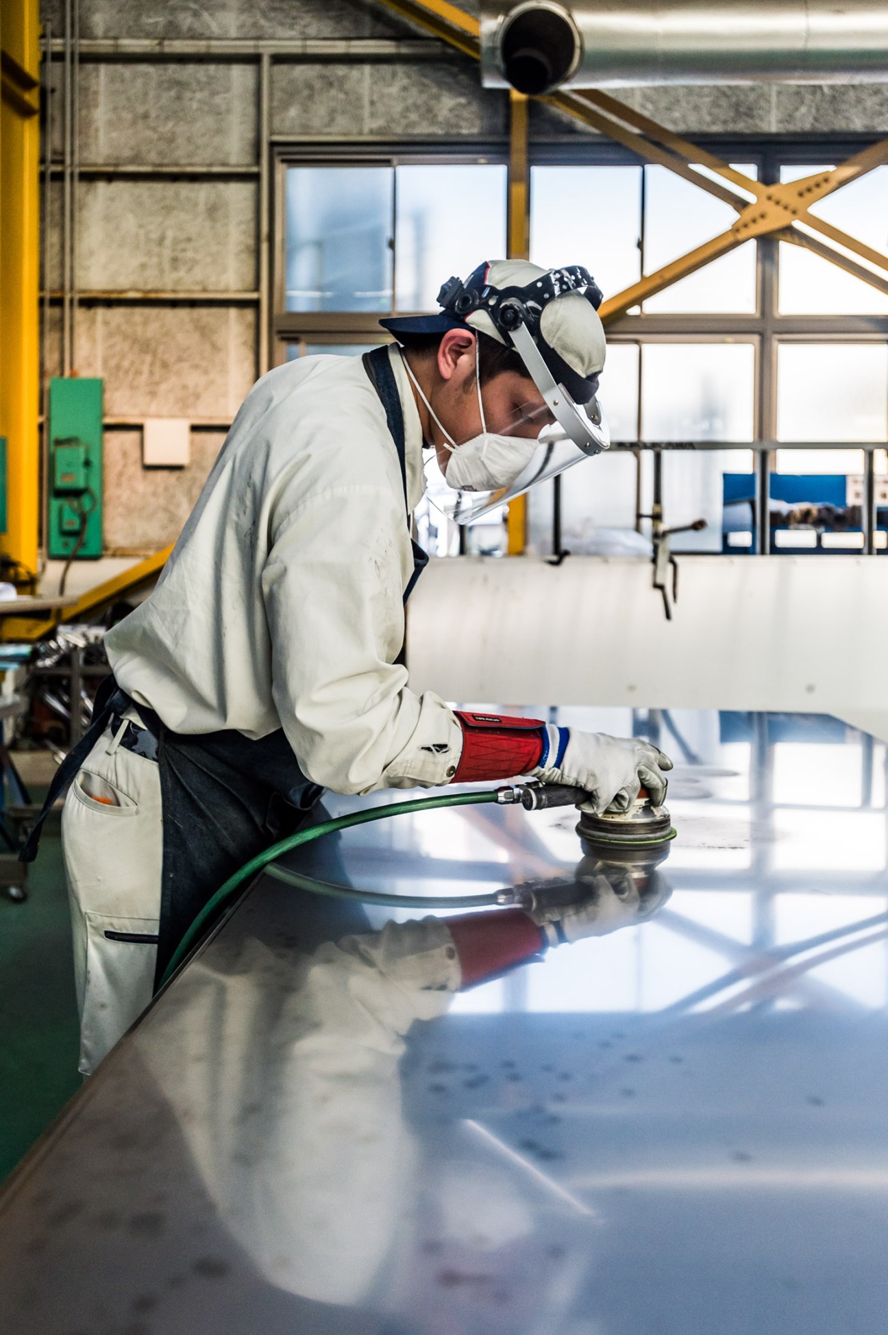 Worker buffing steel to a mirror finish at Kikukawa factory in Japan.