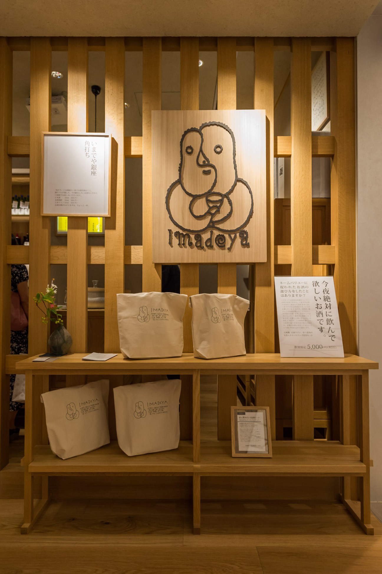 Artist Michiaki Mochizuki's Imadeya logo displayed on wooden signage in the shop.