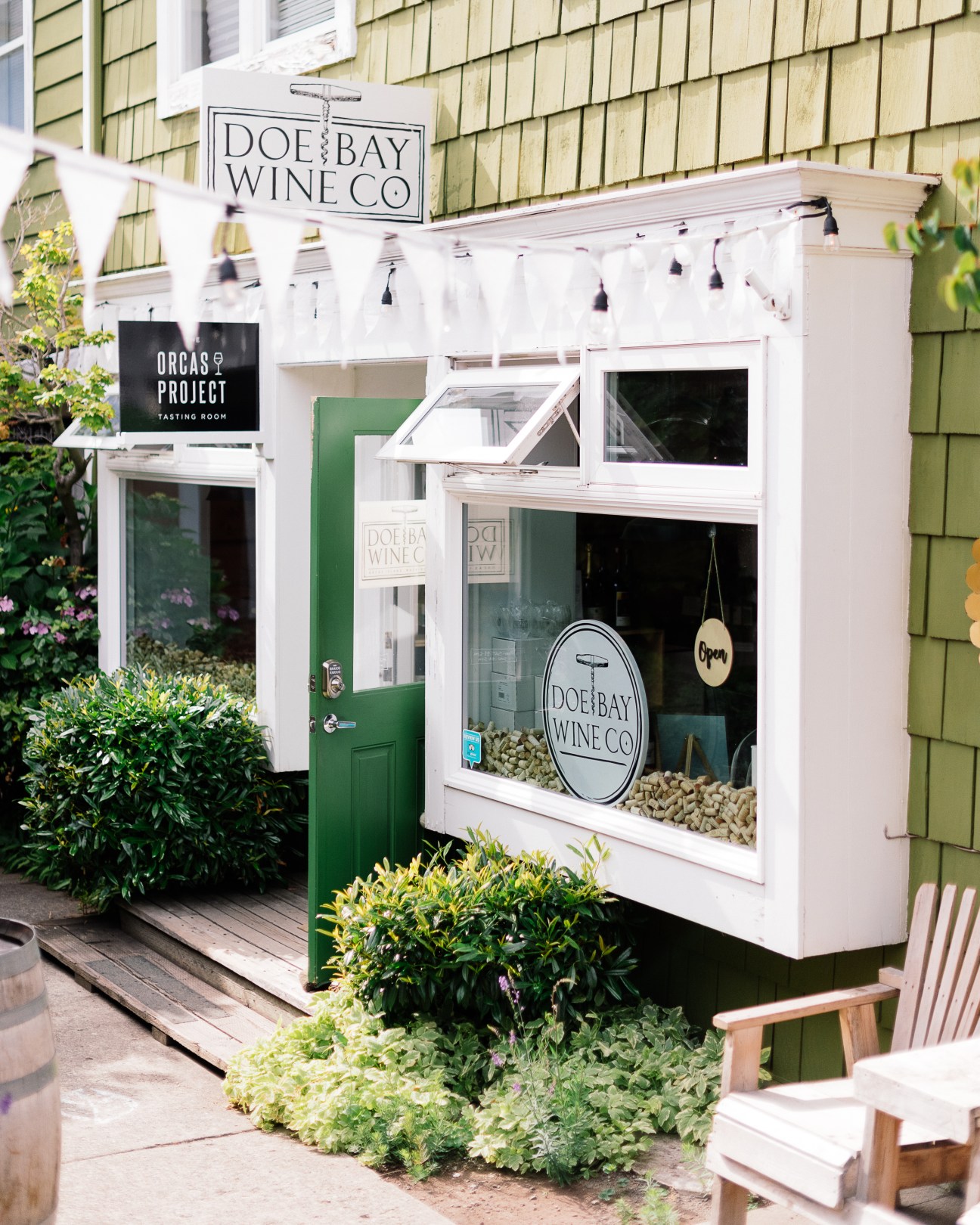 Doe Bay Wine Company storefront with white facade, green door, and large windows displaying wine bottles