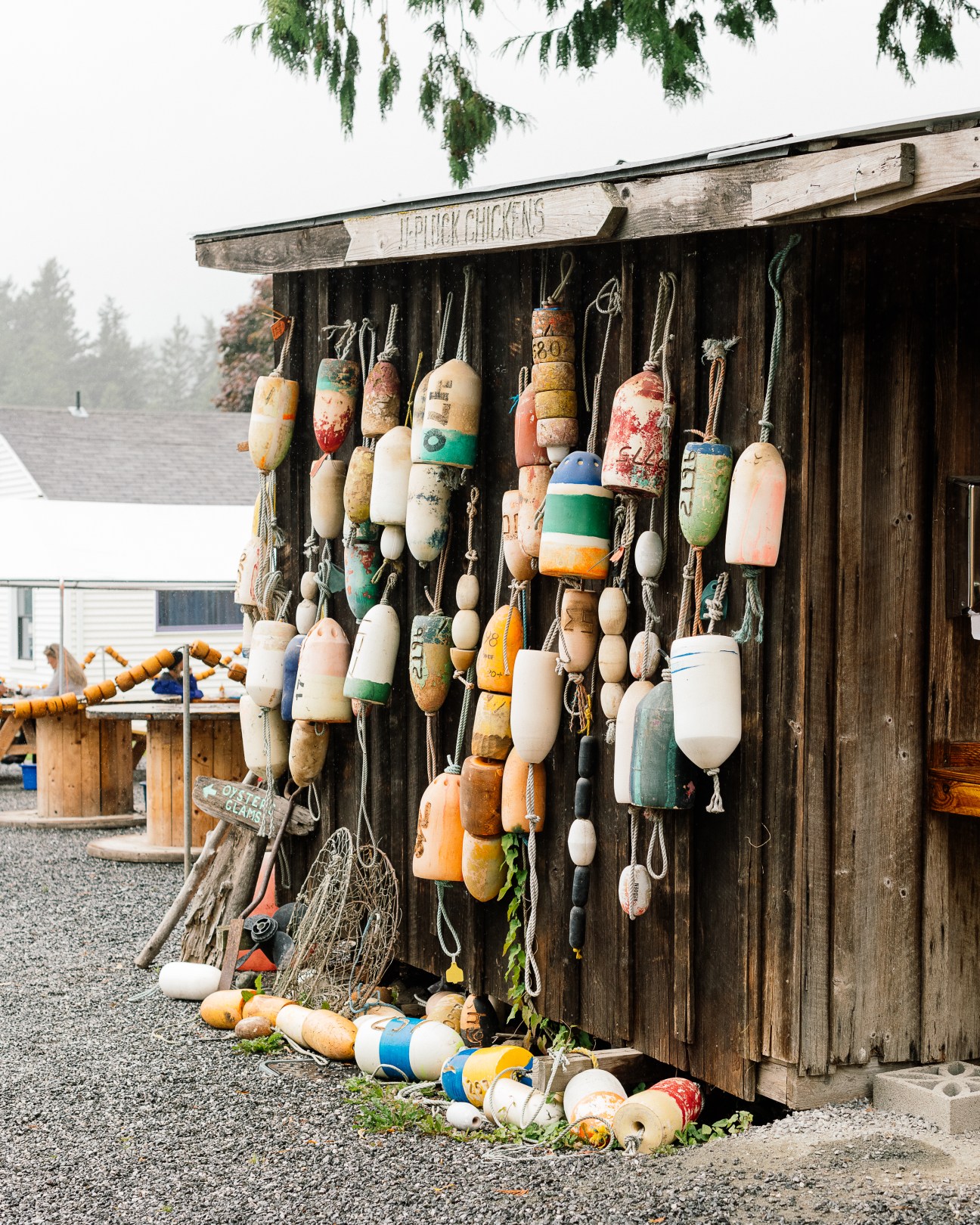 Colorful fishing floats and buoys hanging on weathered wooden building exterior