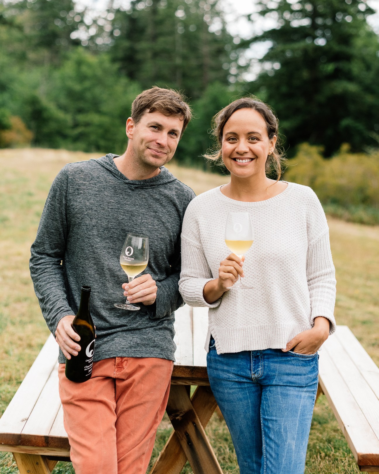 Wes and Tera Landman, co-owners of Orcas Island Winery, holding wine glasses outdoors