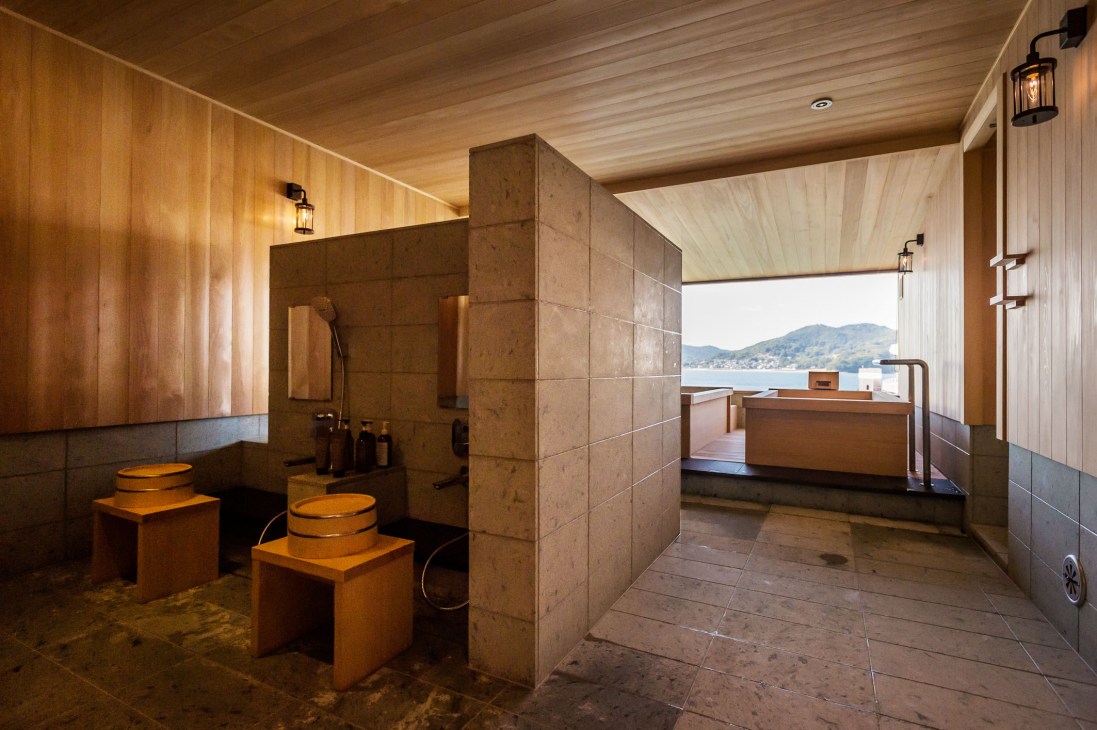 Spa interior with wooden cedar baths and shower area overlooking the Seto Inland Sea from Guntu.