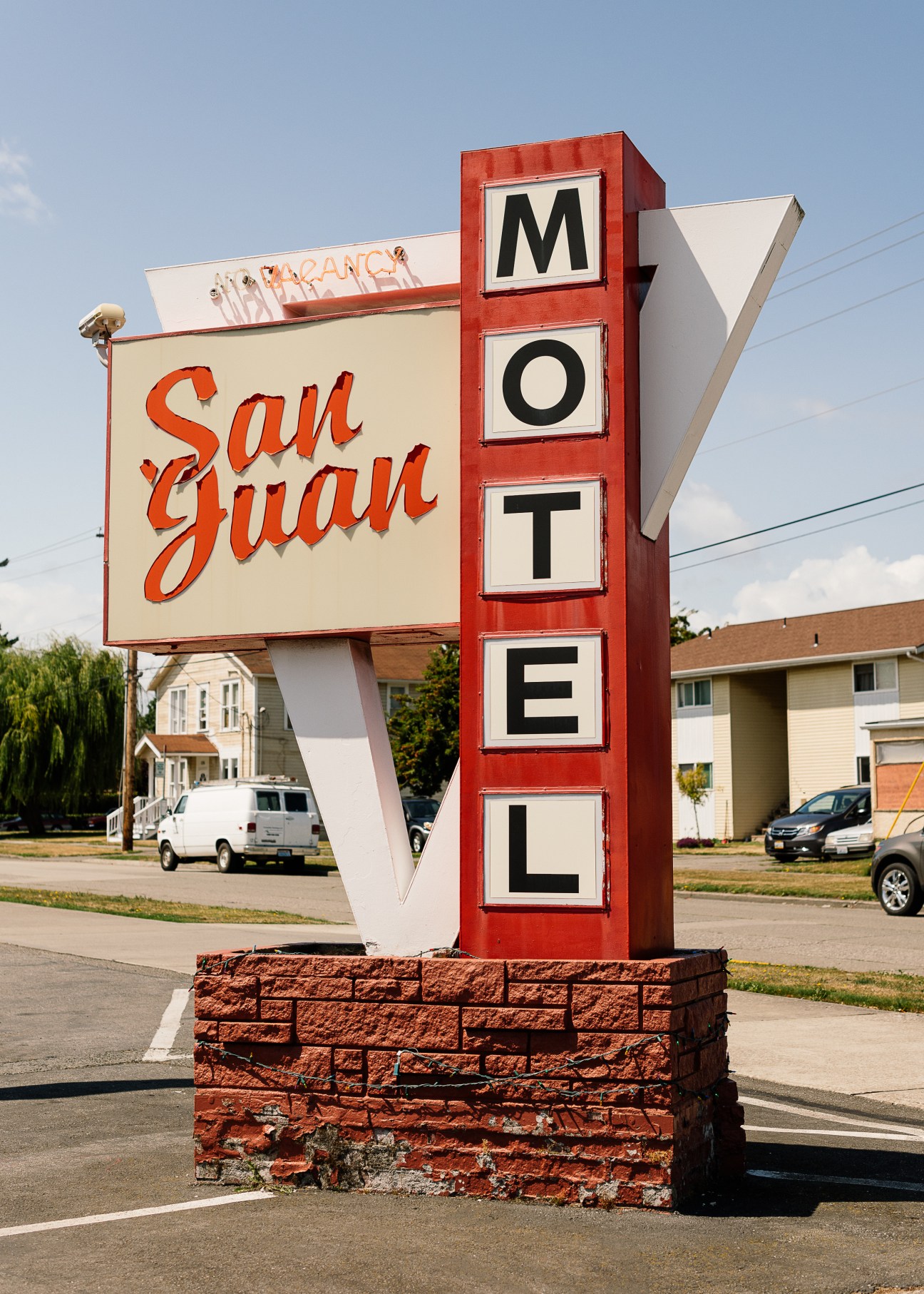 Vintage motel sign reading San Juan with red vertical MOTEL lettering on brick base