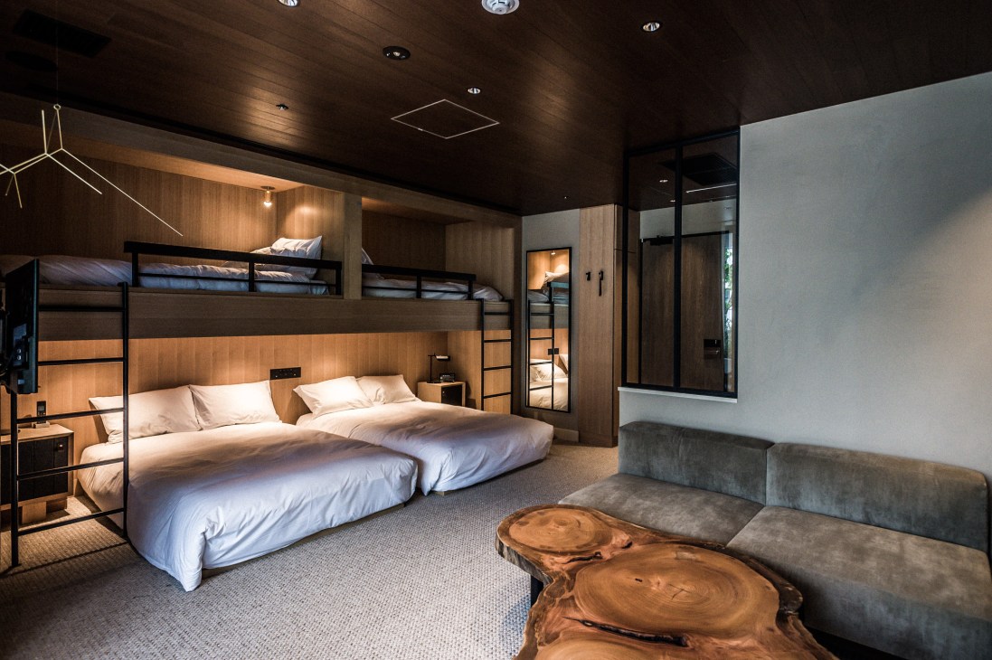 Trunk Hotel Junior Suite with bunk beds, wooden wall panels, and concrete side tables in Tokyo.