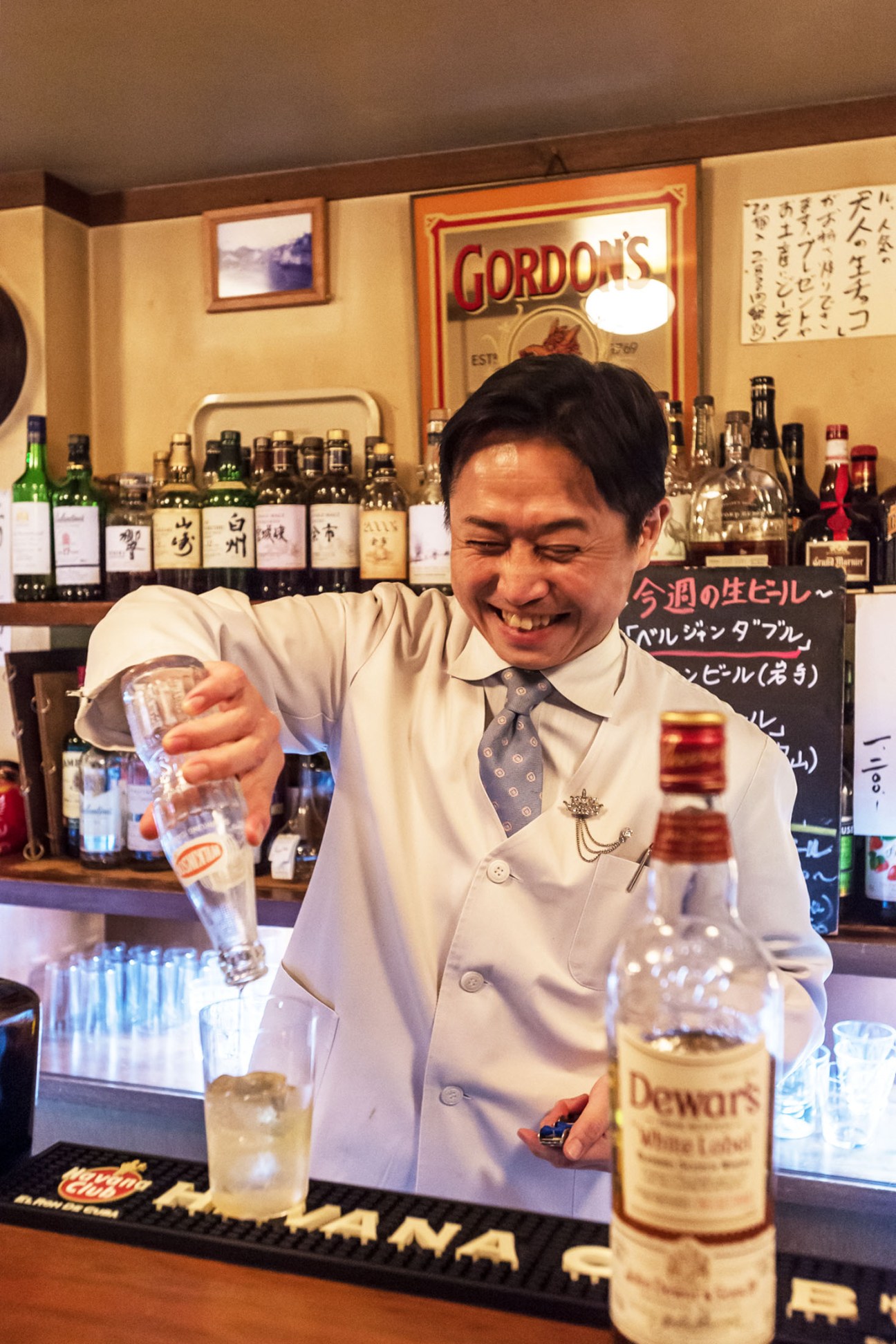 Genki Miyakawa of Hirosaka Highball pouring a drink behind the bar.