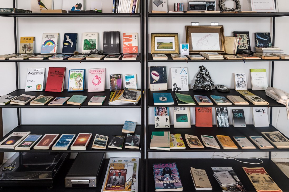 Curated collection of art books and literature displayed on wooden shelves in the lounge