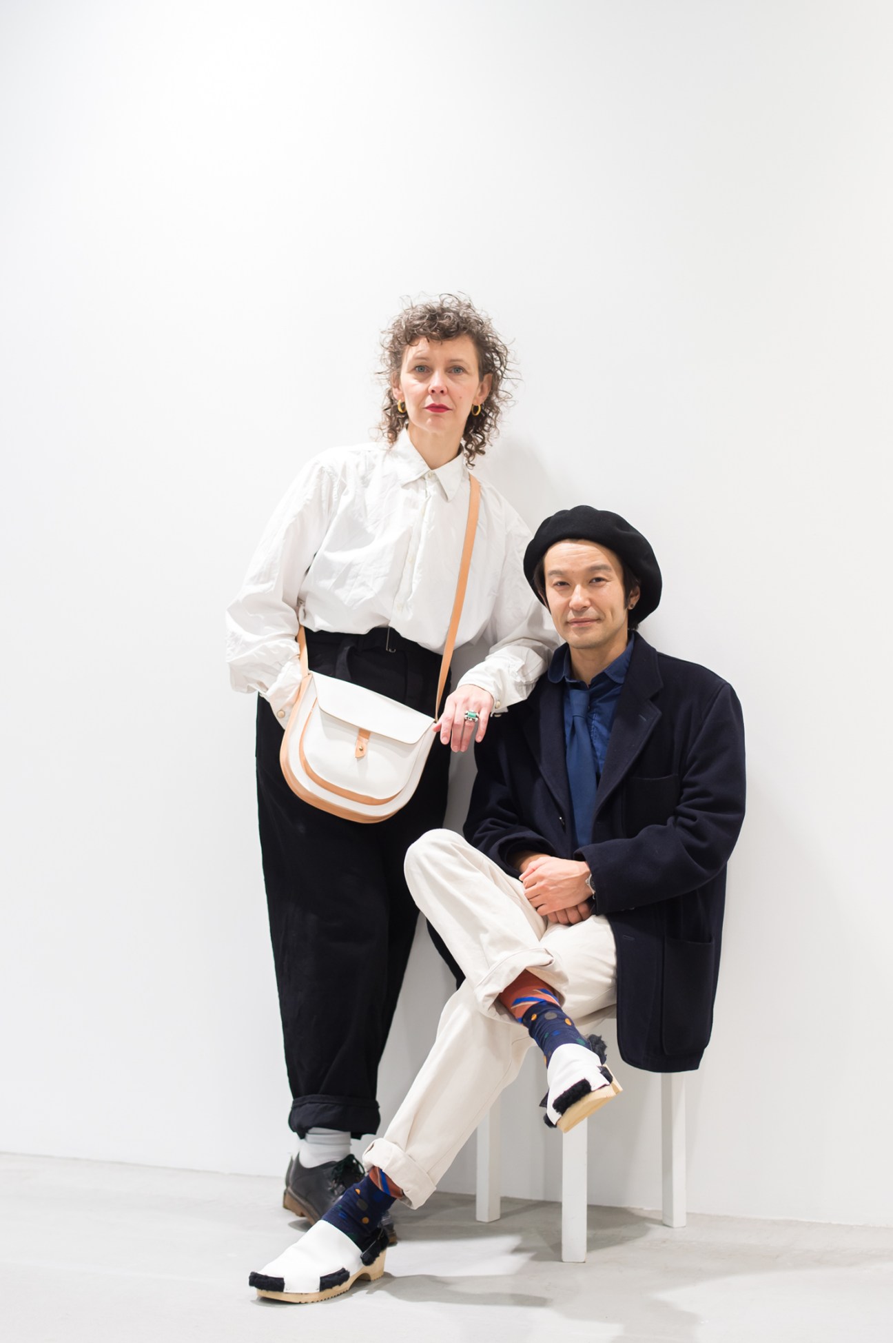 Simone Springer and Yuji Mizobuchi, founders of Rosa Mosa shoe brand, posing together in minimalist white studio