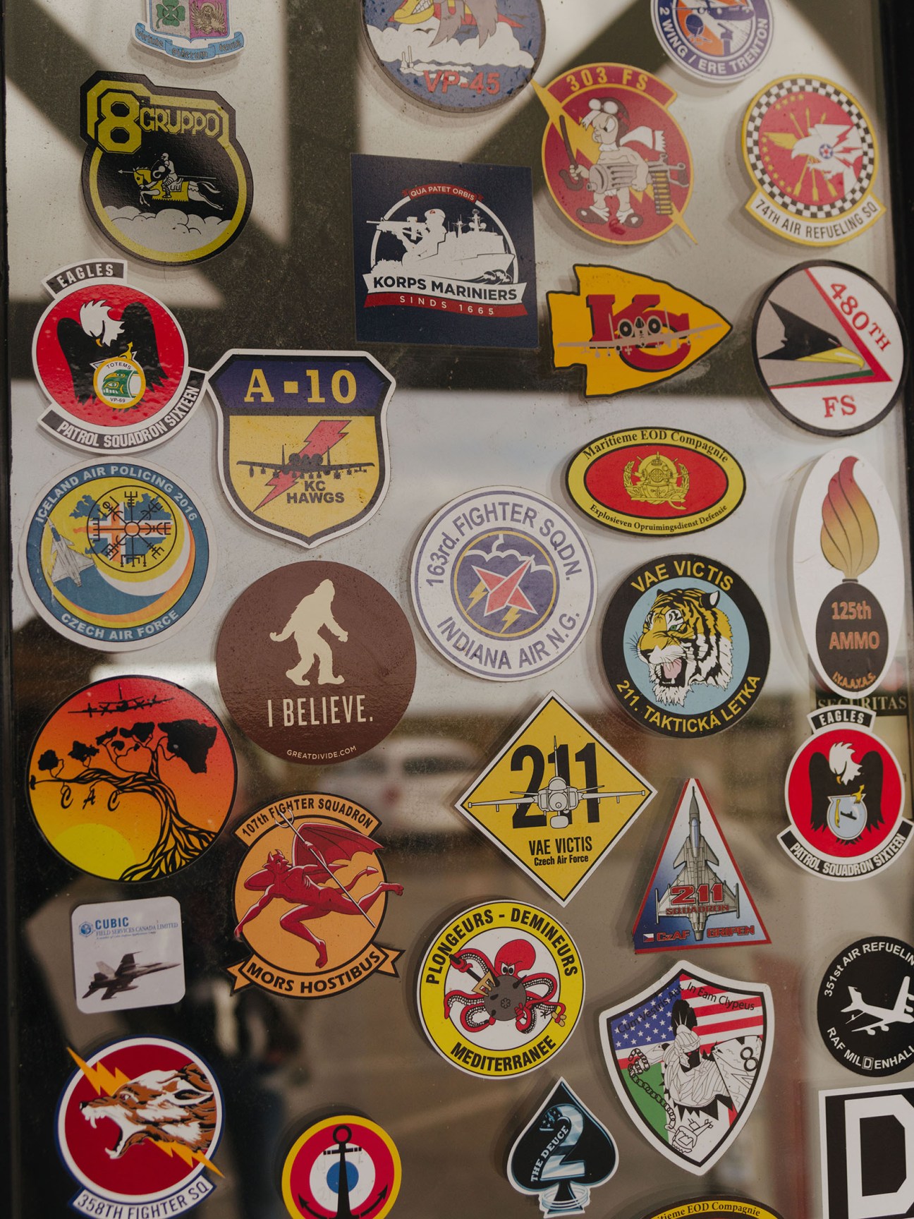 Military squadron patches and stickers featuring various air force emblems and insignia displayed on a light surface.