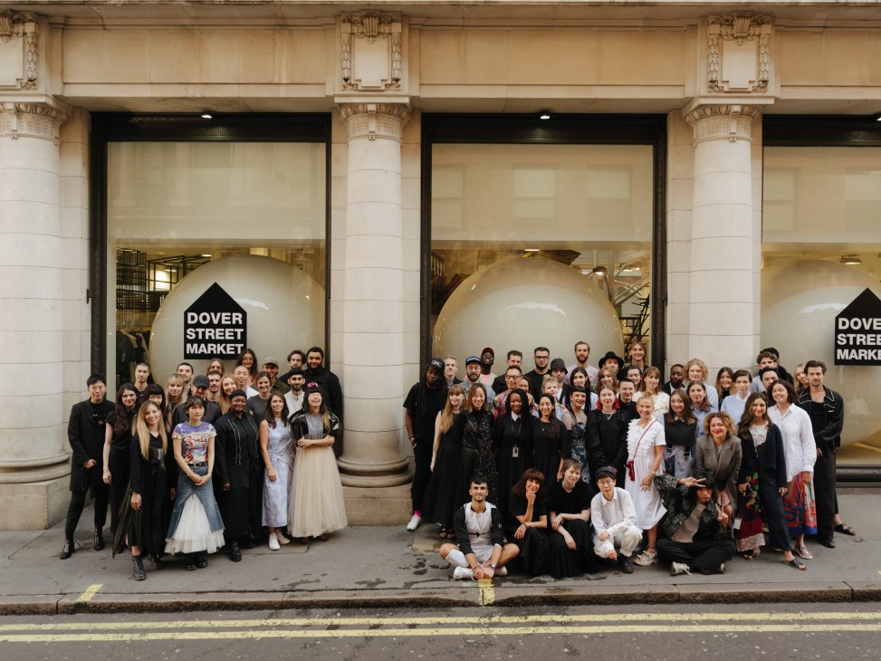 Dover Street Market London team posing outside the store's Piccadilly Circus location with large white spheres and signage visible behind them.