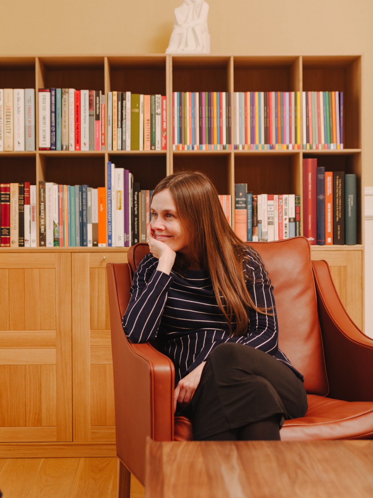 Katrin Jakobsdottir, Iceland's prime minister, sits in a cognac leather chair in her Government House sitting room lined with bookshelves.