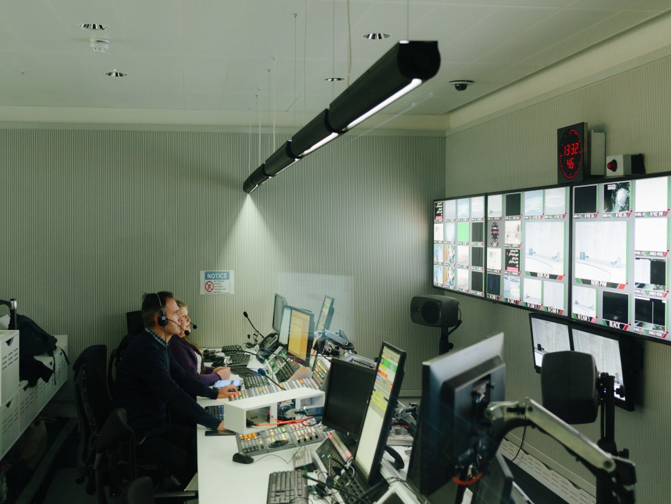 Al Jazeera control room with operators at desks monitoring multiple screens and displays.