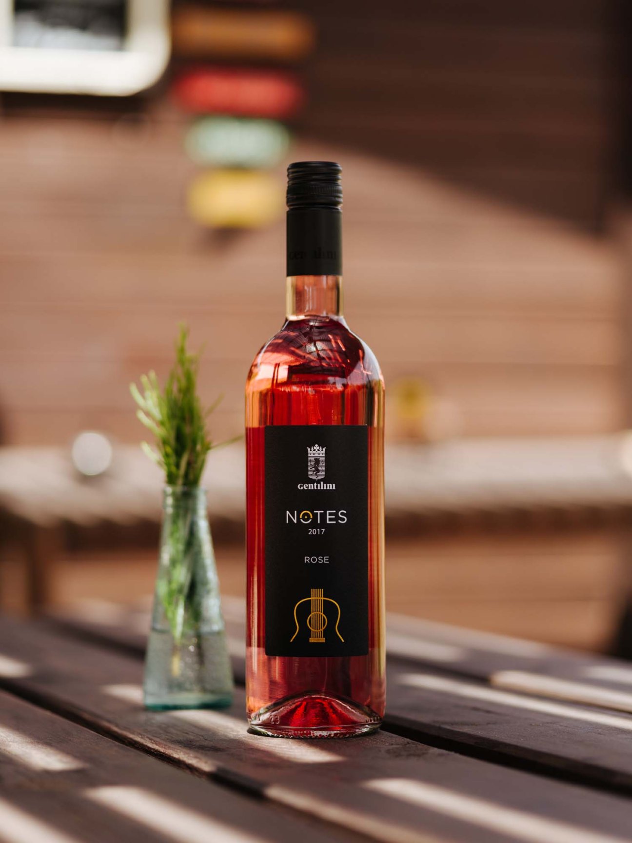 Bottle of Gentilini Notes rosé wine 2017 with black label on wooden table