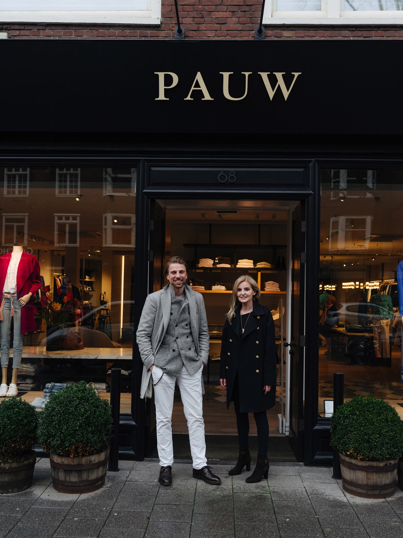 Christiaan Klein-Pauw and Madeleine Pauw standing outside a Pauw shop storefront in Amsterdam.