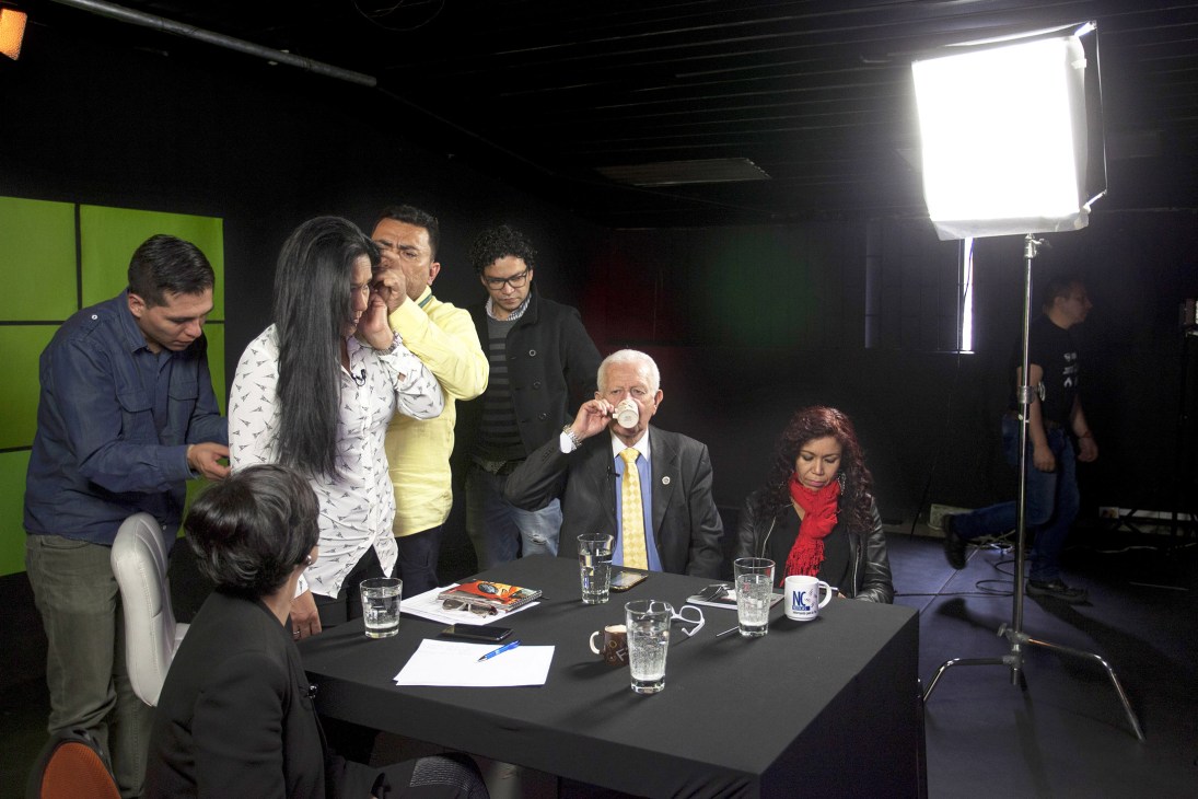 Presenter Marilu Ramirez stands with guests around a table inside NC Noticias studio during a broadcast recording.