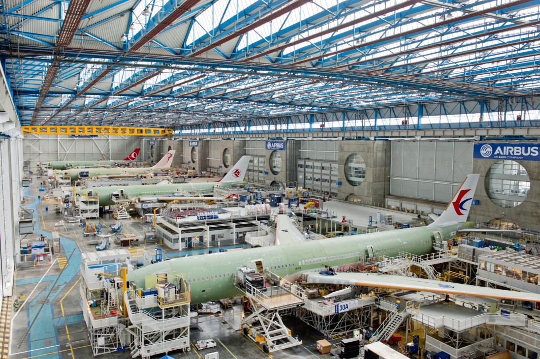 Airbus A320 aircraft on final assembly line with workers and equipment visible