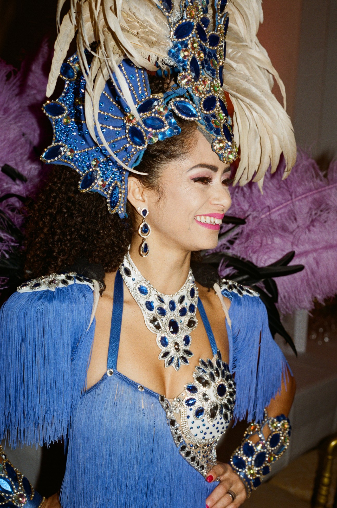 Samba performer in ornate blue costume with feathered headdress and jeweled decorations at Vienna ball