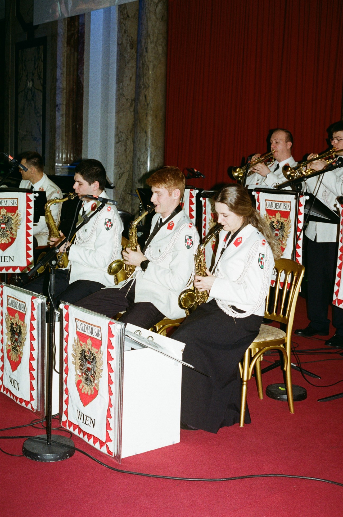 Military band musicians in white uniforms playing brass instruments at Vienna ball venue