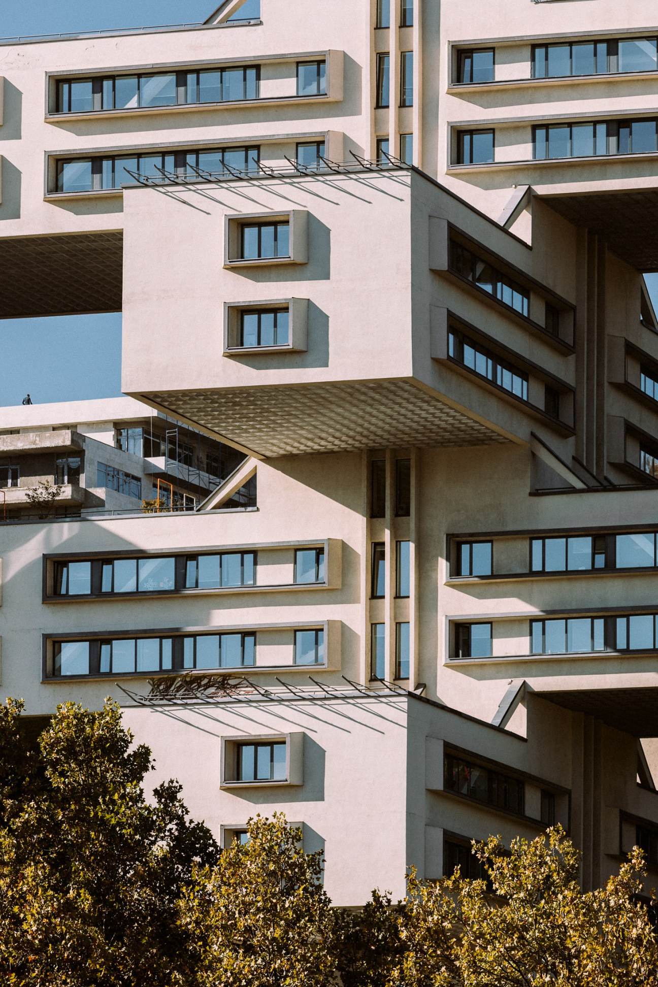 The Bank of Georgia HQ, a 1975 modernist building with pink facade and stacked geometric balconies.