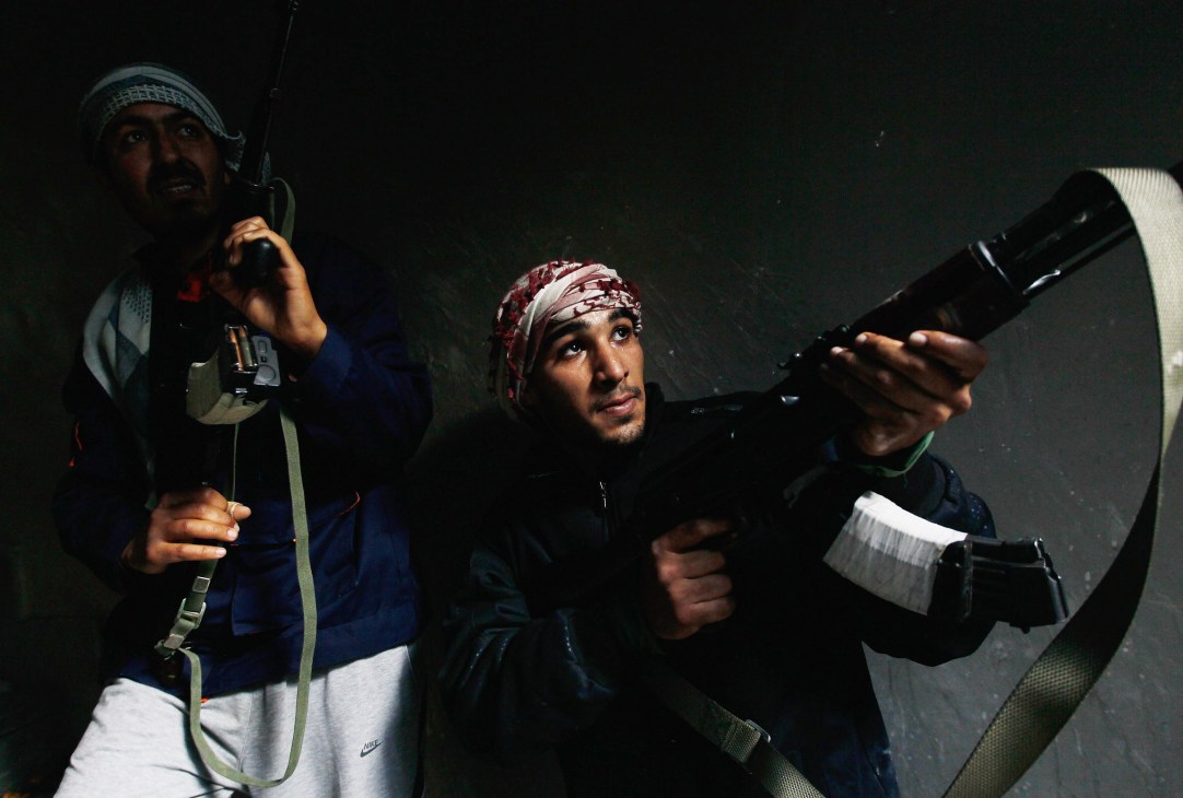 Rebel fighters in Misurata moving into a building containing loyalist troops during armed conflict.