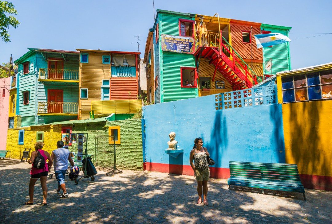 Colorful buildings with bright blue, green, yellow and red corrugated metal facades in La Boca neighborhood.