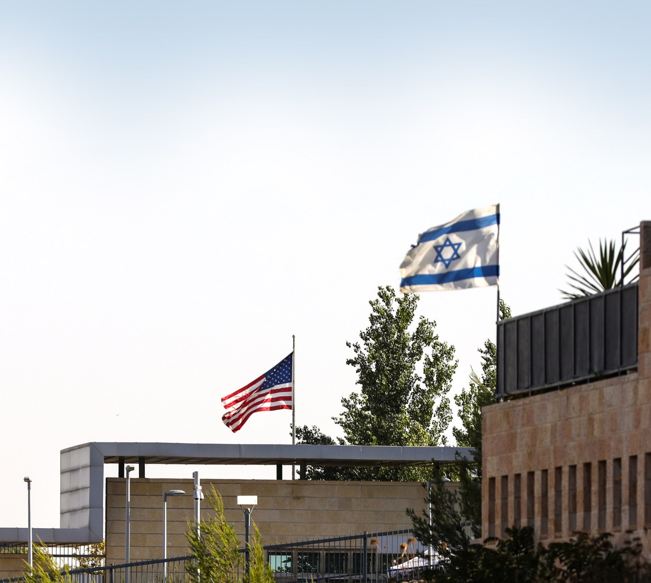 The US embassy building in Jerusalem with American and Israeli flags flying outside.